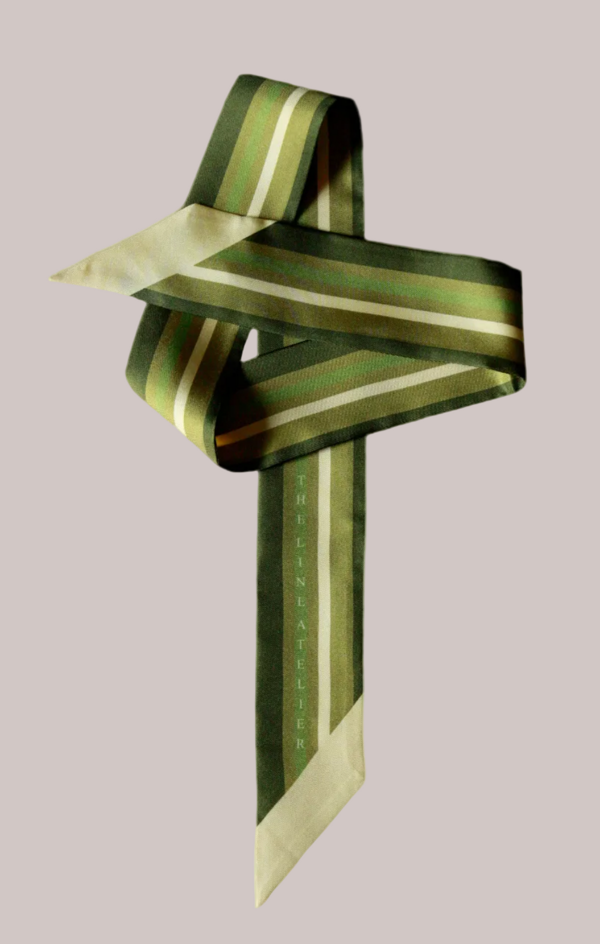 Green and pale gold striped twilly silk scarf on a beige background