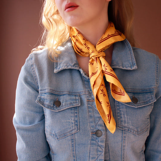 Model wearing Autumn Gold golden silk twilly scarf by The Line Atelier