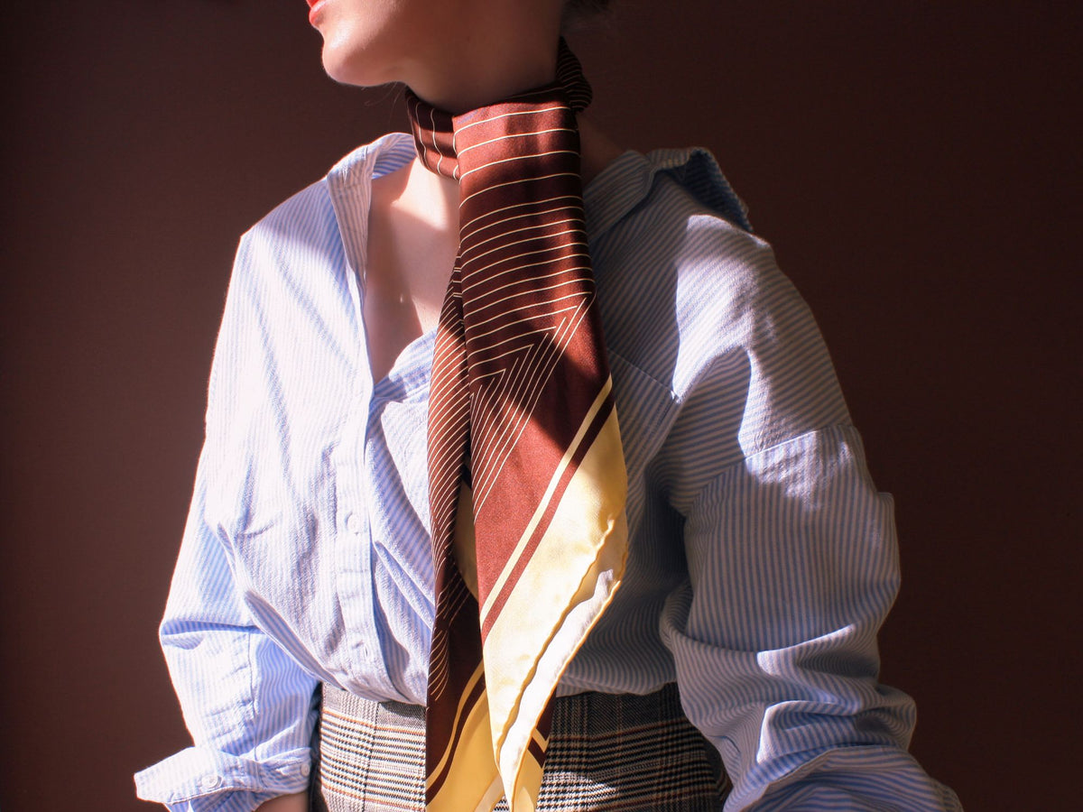 Model wearing the brown and pale gold striped large silk scarf square Rogues Equilibrium by The Line Atelier