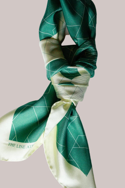 Green and white patterned silk scarf on a white background