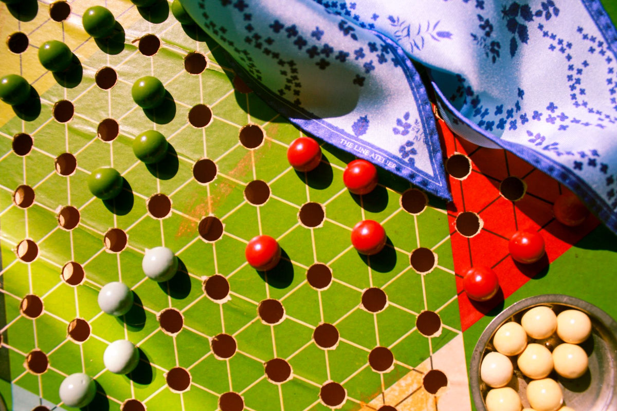 Luminous blue silk scarf laying on old Chinese checkers game