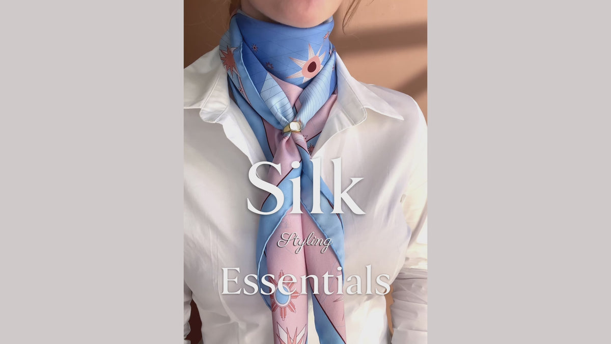 Load video: Silk scarf styling tutorial for how to roll, wrap and secure a large silk scarf using a statement ring, by The Line Atelier