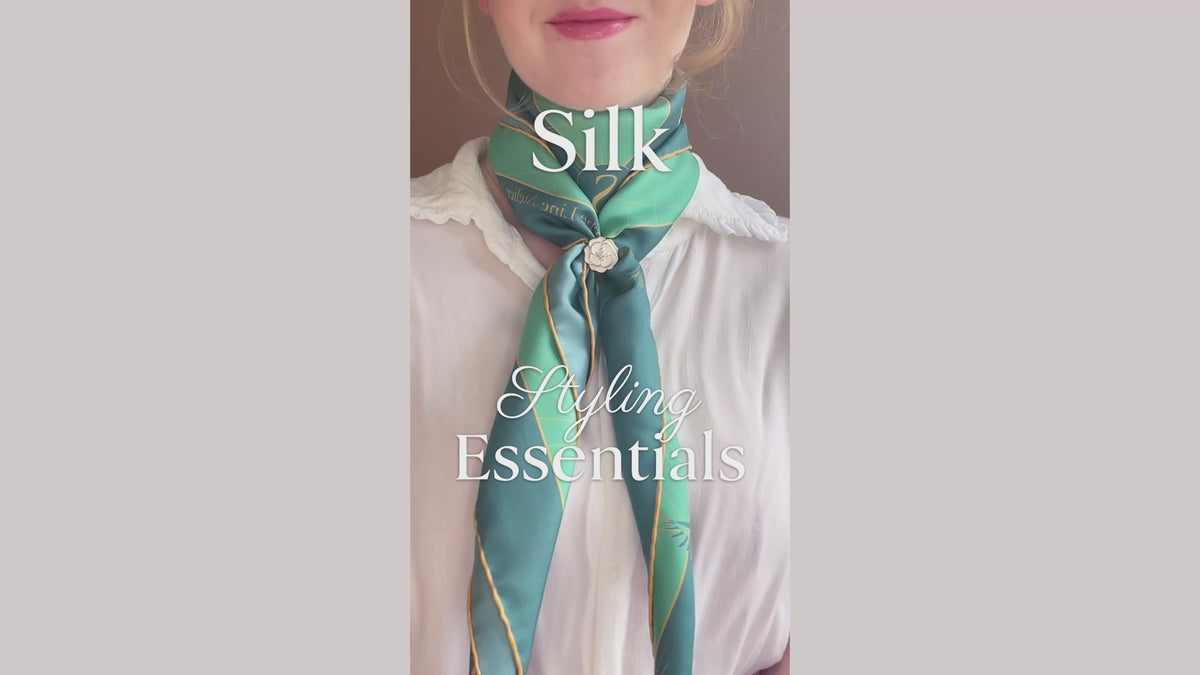 Load video: Silk scarf styling tutorial for how to use a scarf ring on a large silk scarf, by The Line Atelier