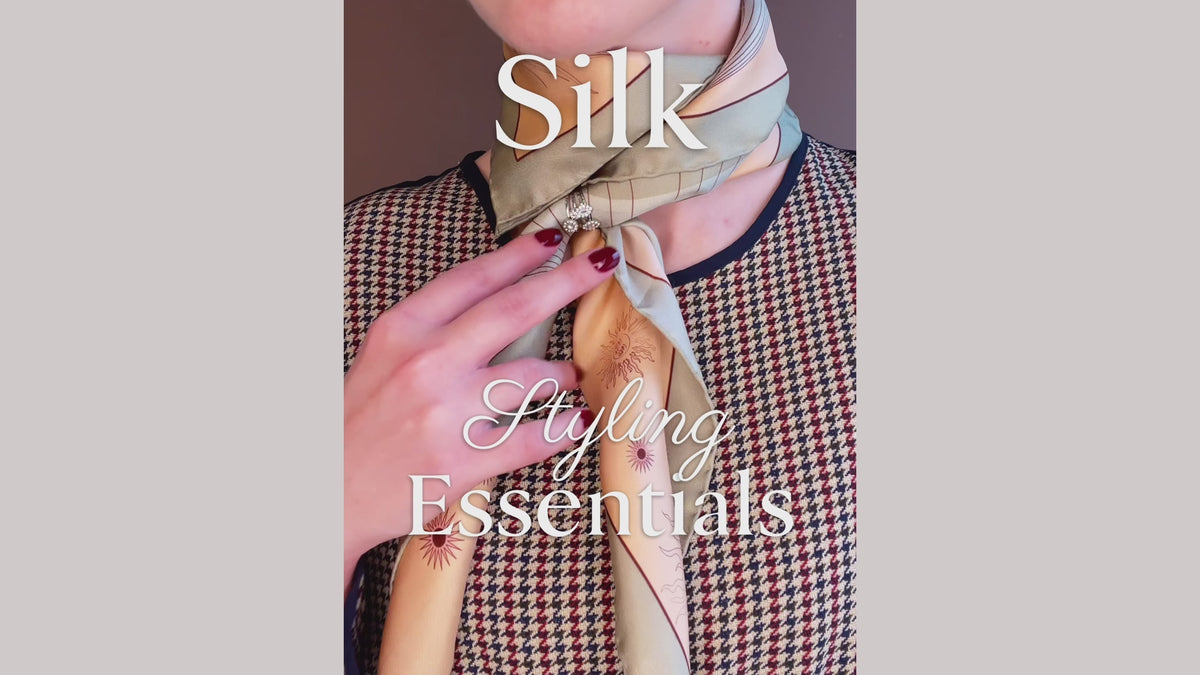 Load video: Silk scarf styling tutorial for how to roll, wrap and secure a large silk scarf using a stack of rings, by The Line Atelier