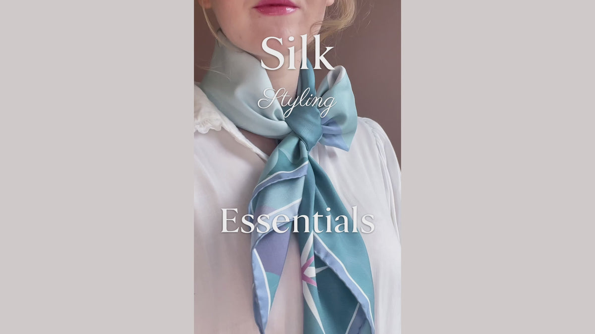 Load video: Silk scarf styling tutorial for how to roll, tie and secure a large silk scarf in a bow fashion, by The Line Atelier
